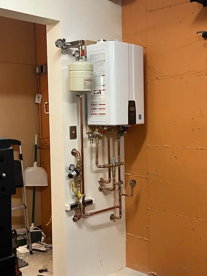 Plumbing technician inspecting water heater connections in Coventry